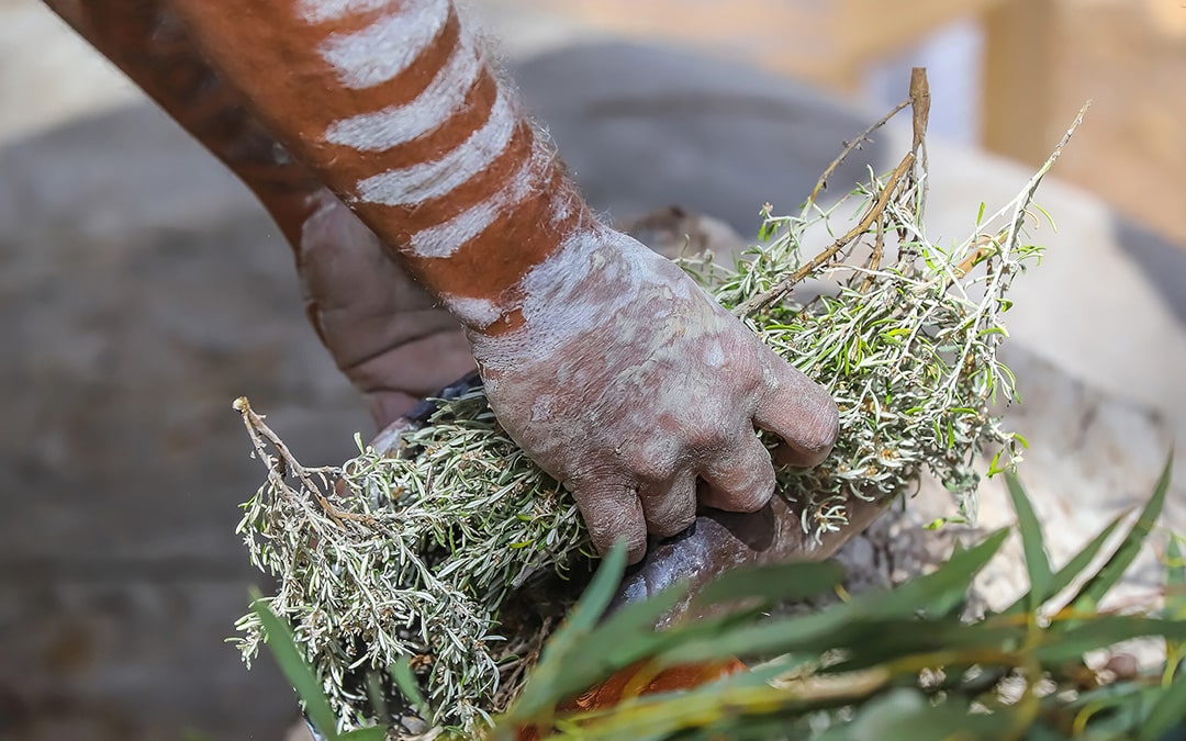 Human,hands,with,green,branches,,wooden,ritual,dish,and,fire,